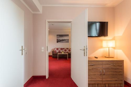 a room with a red carpet and a living room at Hotel Wetterstein in Munich