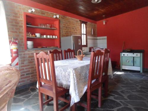 a kitchen with a table and chairs and red walls at El Churqui in Humahuaca