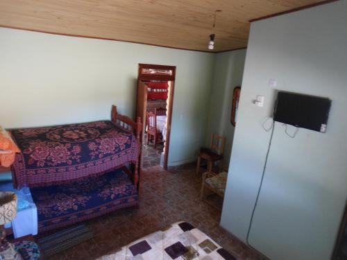 a room with a bed and a refrigerator and a tv at El Churqui in Humahuaca