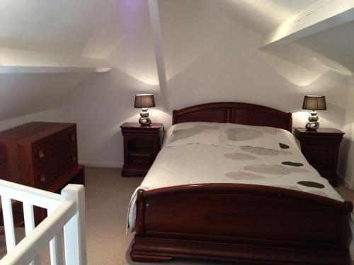 a bedroom with a bed with two night stands and two lamps at les gites du gr224 in Pont-Audemer