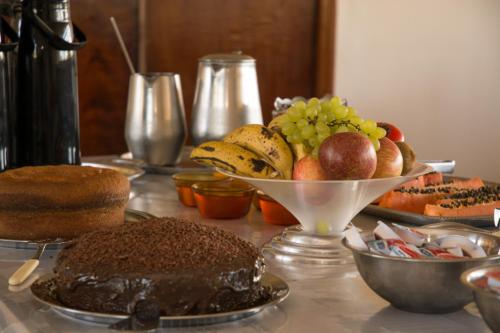 un tavolo con una torta e un cesto di frutta di Coesa Hoteis a Casa Branca