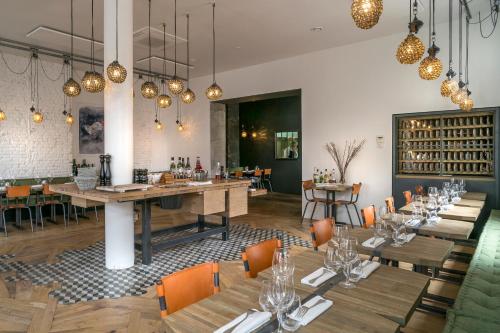 une salle à manger avec tables, chaises et lustres dans l'établissement Best Western Hôtel Hermitage, à Montreuil-sur-Mer