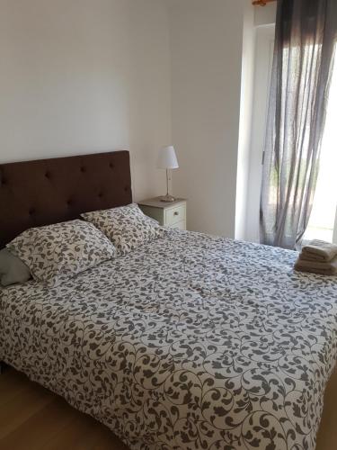 a bed with a black and white comforter in a bedroom at Casa Pedrada in Zaragoza