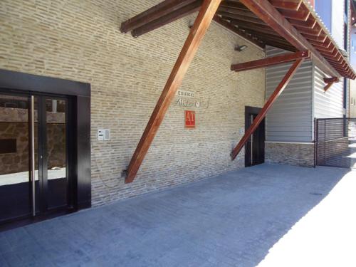 a brick building with wooden beams on the side of it at Nievemar Edificio Monte Oiz in Sierra Nevada