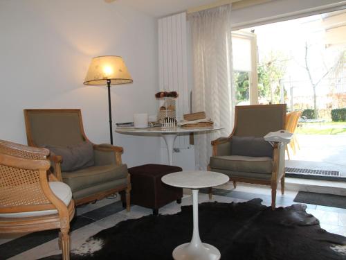 ein Wohnzimmer mit Stühlen, einem Tisch und einem Fenster in der Unterkunft Welcoming Holiday Home in Heiloo in Heiloo