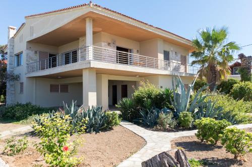 a house with a balcony and some plants at Sunset Beach House in Kato Alepochori