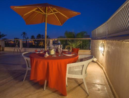 a table with an umbrella on a patio at Riad Charaï in Marrakesh