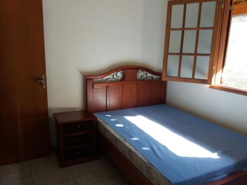a bedroom with a wooden bed and a window at Recanto Almada Gabriel in Juiz de Fora