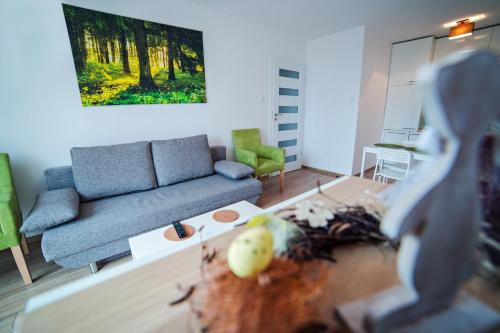 uma sala de estar com um sofá e uma mesa em Apartament Mięta em Karpacz