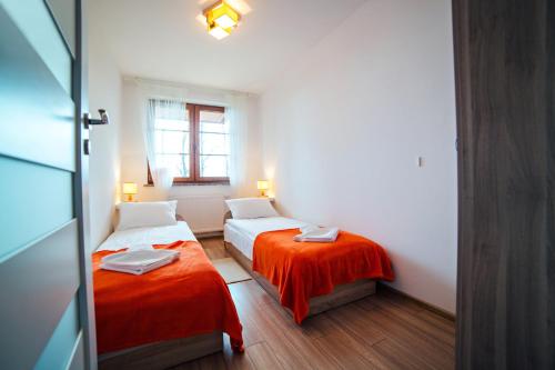 a small room with two beds and a window at Apartament Mięta in Karpacz