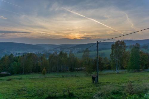 a field with a telephone pole in a field at Ferienwohnung Lämpelberg in Klingenthal