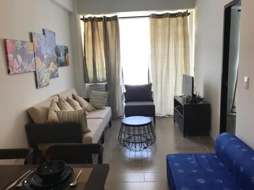 a living room with a couch and a table at Boracay Oceanway Residences - Island Paradise in Boracay