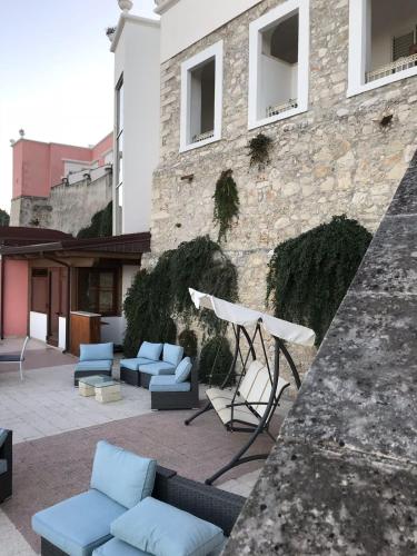 a patio with blue chairs and a table and a building at Hotel Boutique Il Castellino Relais in Vieste