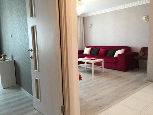 a living room with a red couch and a table at Centre-Port apartment in Kherson