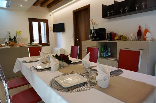 a table with a white table cloth and red chairs at B&B HORTUS in Venice