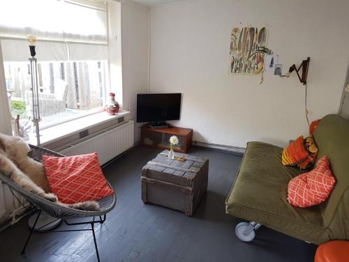 a living room with a couch and a chair at Hotel B&B Altijd Wad in West-Terschelling