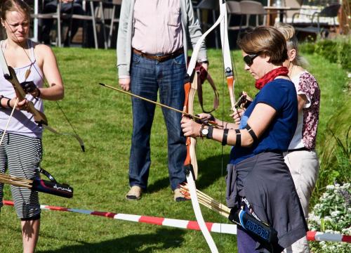 a group of people playing a game of bow and arrow at Familotel Strandkind in Pelzerhaken