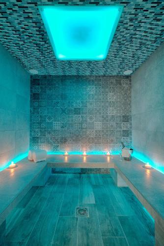 a swimming pool with blue lights in a room at Logis Aux Maisons in Maisons-lès-Chaource