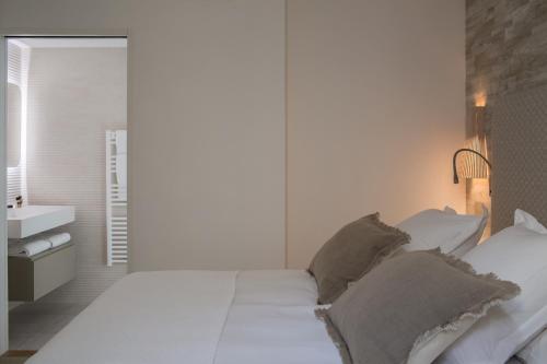 a bedroom with a large white bed with pillows at Villa Reale in Bordeaux