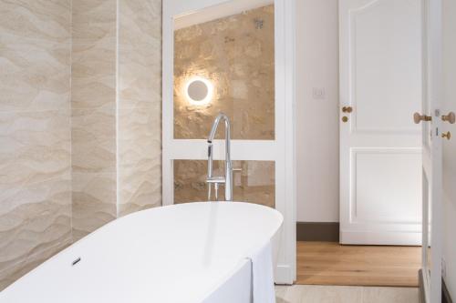 a bathroom with a white tub and a mirror at Villa Reale in Bordeaux