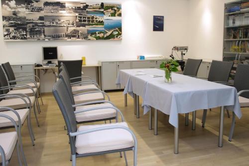 a dining room with white tables and chairs at Hotel Villa Radin in Vodice