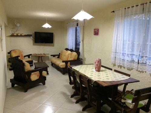 a living room with a table and chairs and a couch at Casa Confortável - Cabo Frio in Cabo Frio