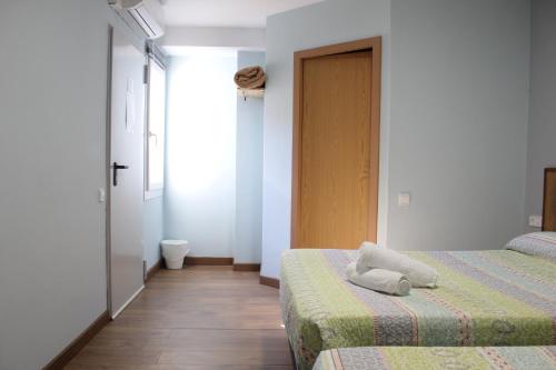 a hotel room with two beds and a door at L'Hostalet d'Arenys de Mar in Arenys de Mar