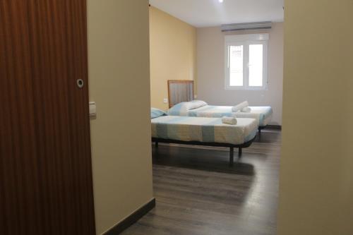 a room with two beds and a window at L'Hostalet d'Arenys de Mar in Arenys de Mar