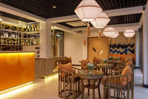a restaurant with tables and chairs and a bar at 9 SUITE Luxury Boutique Hotel in Chiang Mai