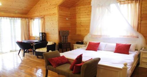 a bedroom with a large white bed with red pillows at Luka Garden BnB in Renai