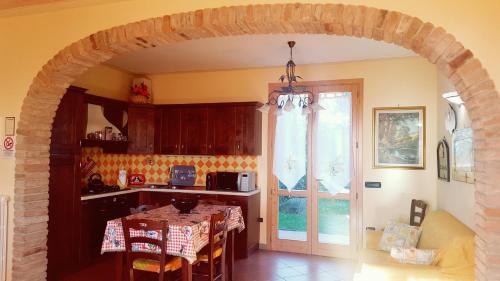 arco in cucina con tavolo e cucina di Villa Antico Borghetto Di Tigliano a Vinci