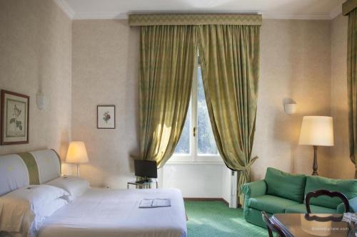 a bedroom with a bed and a couch and a window at Aldrovandi Residence City Suites in Rome