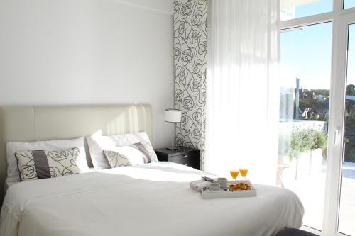ein weißes Bett mit einem Tablett mit Essen drauf. in der Unterkunft Apartamento Playas Carilo in Carilo