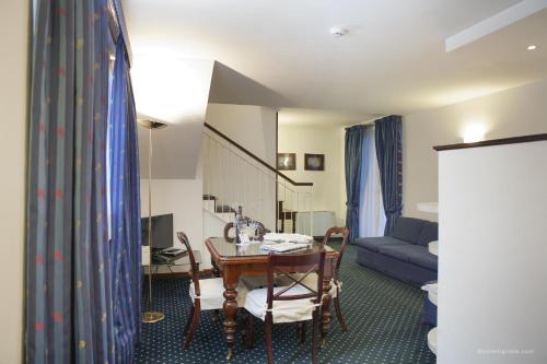 a living room with a table and a couch at Aldrovandi Residence City Suites in Rome