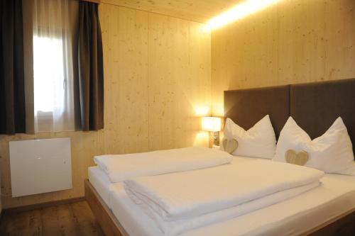 ザンクト・ミヒャエル・イム・ルンガウにあるPremium Appartements Sonnenbahnのベッドルーム1室(白いシーツ付きのベッド1台、窓付)