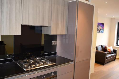 a kitchen with a stove top oven next to a living room at Kings Cross Apartment 5/Apartment in London