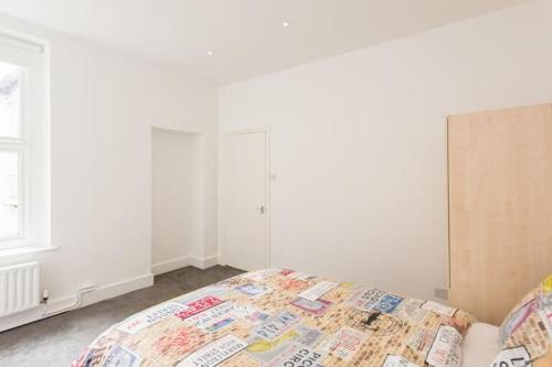 ein Schlafzimmer mit einem Bett und einer weißen Wand in der Unterkunft Kennington Apartment 1/Apartment in London