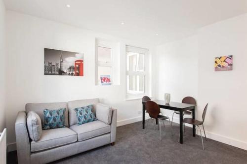 ein Wohnzimmer mit einem Sofa und einem Tisch in der Unterkunft Kennington Apartment 1/Apartment in London