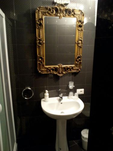 a bathroom with a sink and a mirror at Palace B&B in Acquaviva delle Fonti