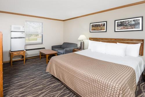 a hotel room with a bed and a chair at Knights Inn Jacksonville in Jacksonville
