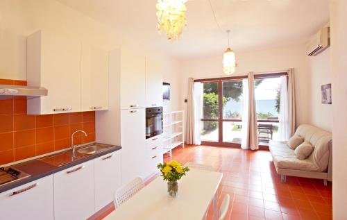 a kitchen with a table with a vase of flowers on it at Pinus Village Sea Front Apartment in Pula