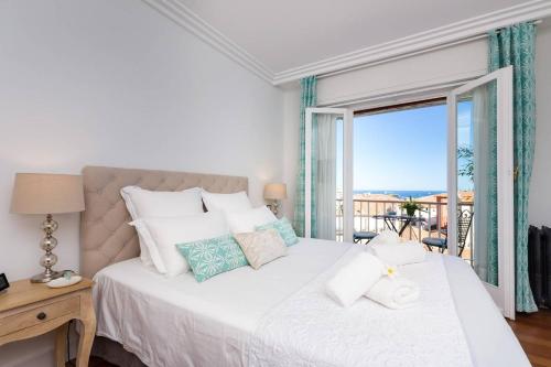 a bedroom with a large bed with a view of the ocean at Le Corot in Beaulieu-sur-Mer