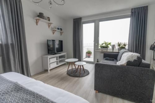 a living room with a couch and a tv at Ansbachs City Apartment in Ansbach