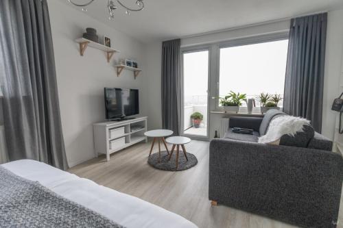 ein Wohnzimmer mit einem Sofa und einem TV in der Unterkunft Ansbachs City Apartment in Ansbach