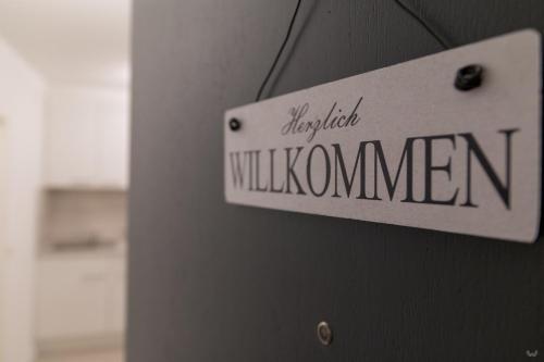 un panneau sur le côté d'un bâtiment avec le mot willuminati dans l'établissement Ansbachs City Apartment, à Ansbach