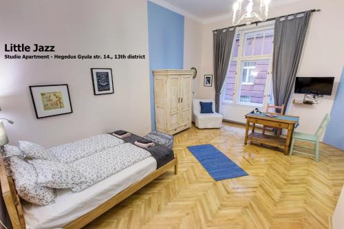 a bedroom with a bed and a wooden floor at Little Americas Concert Hall Apts in Budapest