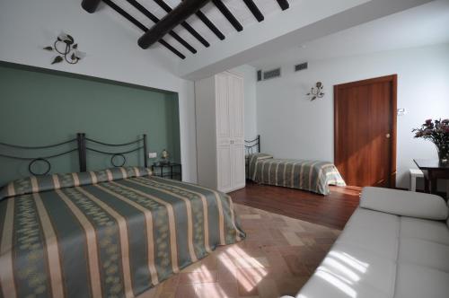 een slaapkamer met een bed en een bank bij Residenza Scorcio Sul Mare in Porto San Giorgio