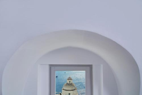 a white archway with a picture of a lighthouse at Aroma Suites in Fira