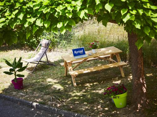 a sign on a picnic table next to a tree at Kyriad Digne-Les-Bains in Digne-les-Bains