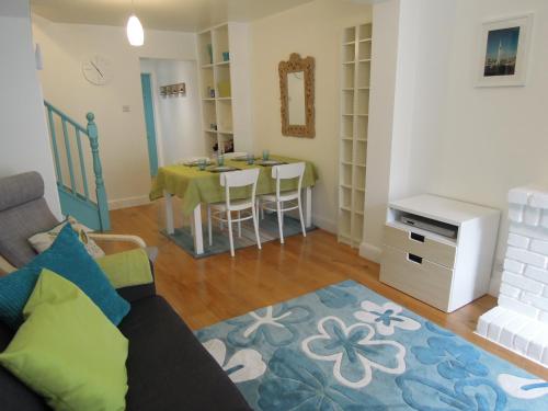 a living room with a couch and a table at Pretty Victorian Cottage in Portsmouth